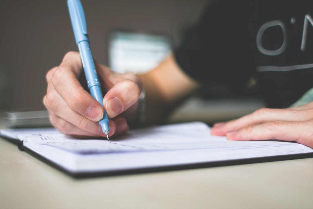 A hand writing on a list - Photo by picjumbo.com on Pexels