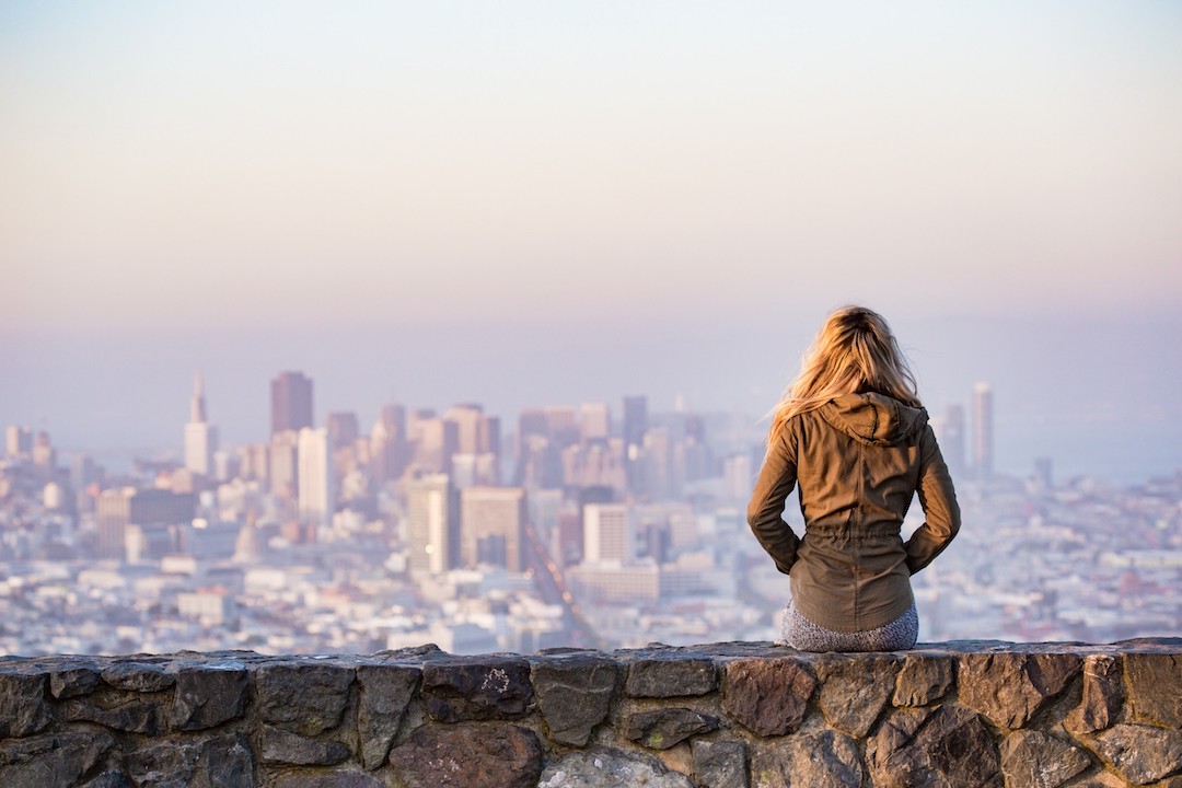 Lady in front of a city - photo: adventure-architecture-bay from Pexels