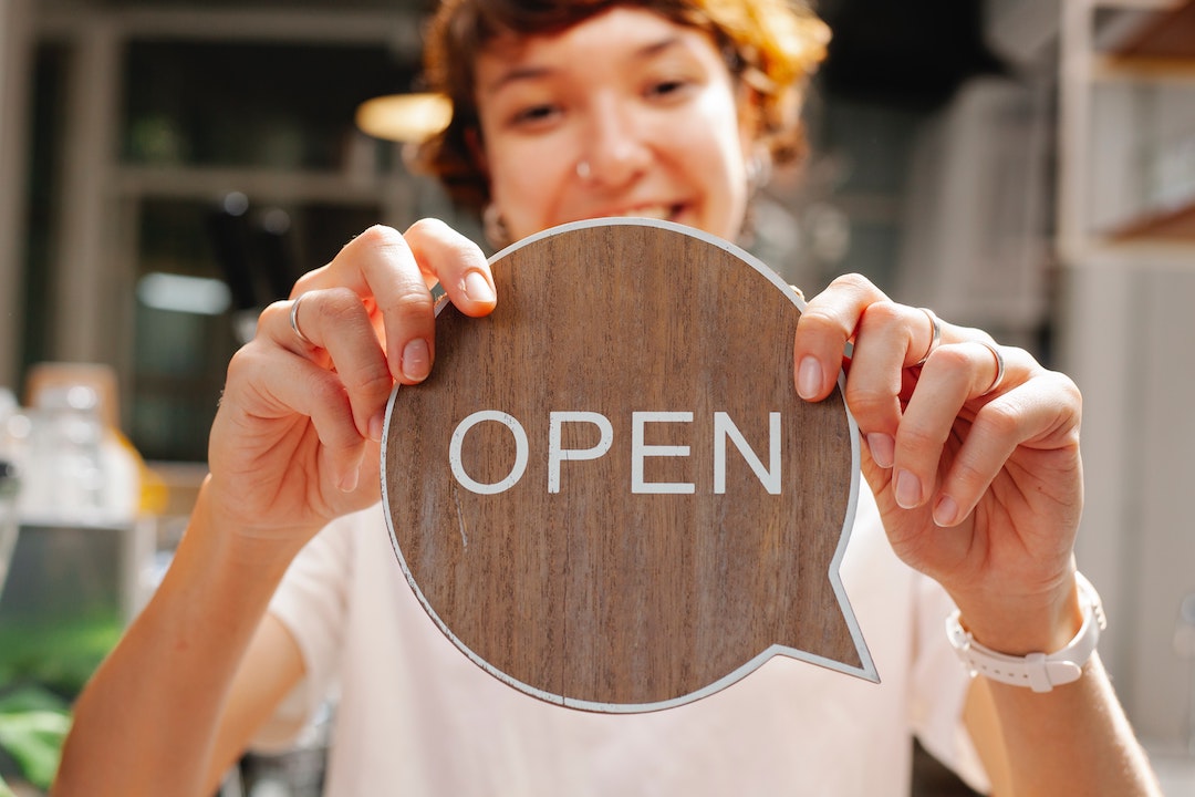 Preheader - lady with a wooden Open sign