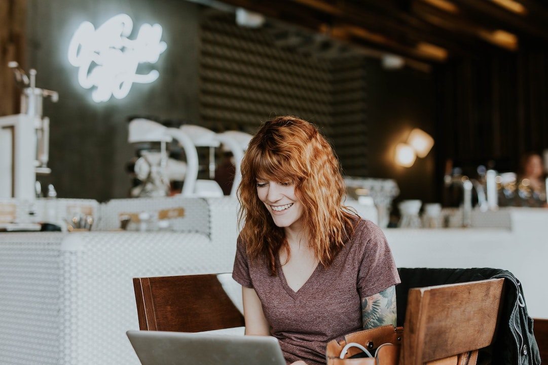Emails you need to send - Lady with a smile infront of a computer