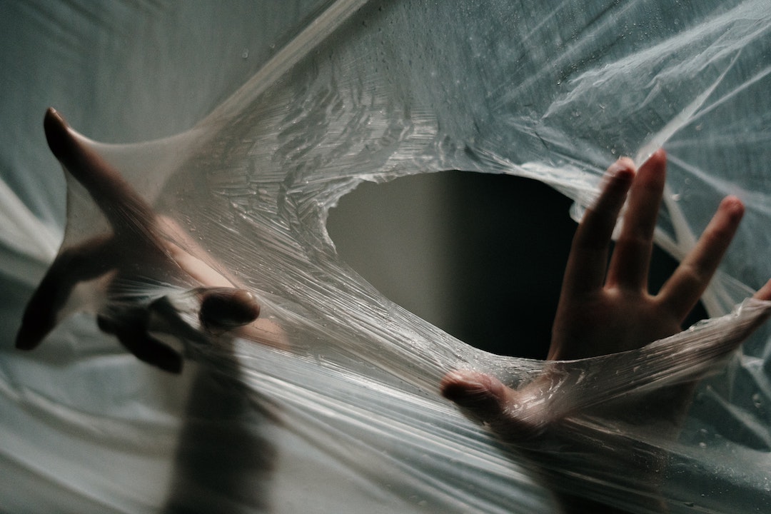 Spam traps - photo of hands coming through a hole in a clear plastic sheet