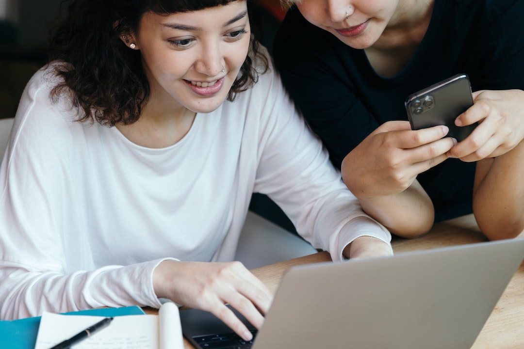 Women infront a computer with a cellphone - Photo Ketut Subiyanto - Pexels