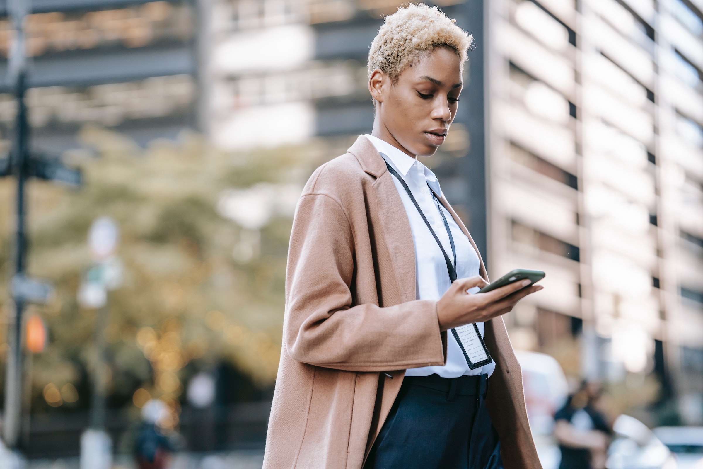 Photo of a woman in a city looking at her cellphone - Photo by Ono Kosuki - Pexels