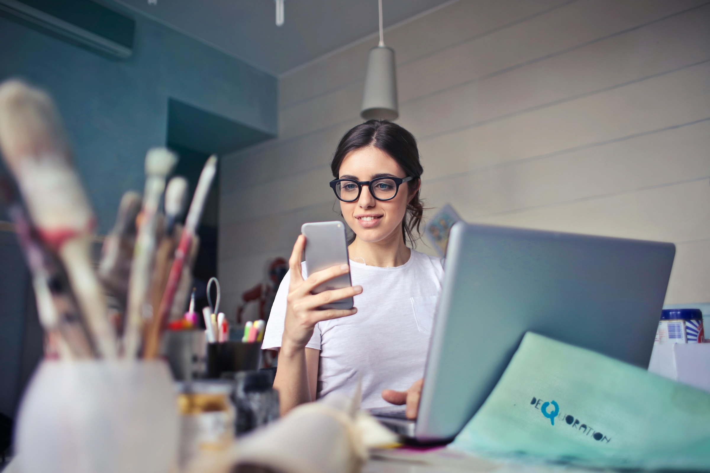 Woman working and looking at phone. - Photo Andrea Piacquadio - Pexels