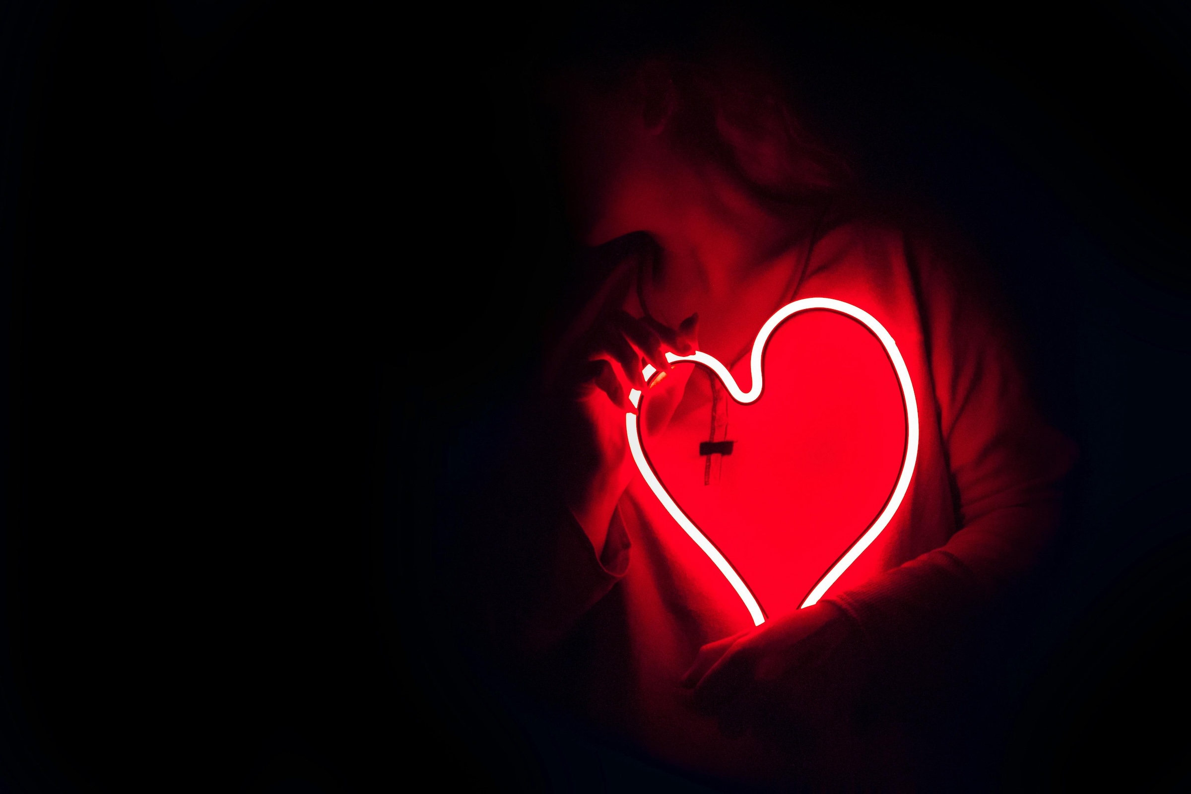 Someone holding a neon heart in his hands - photo by Designecologist - Pexels