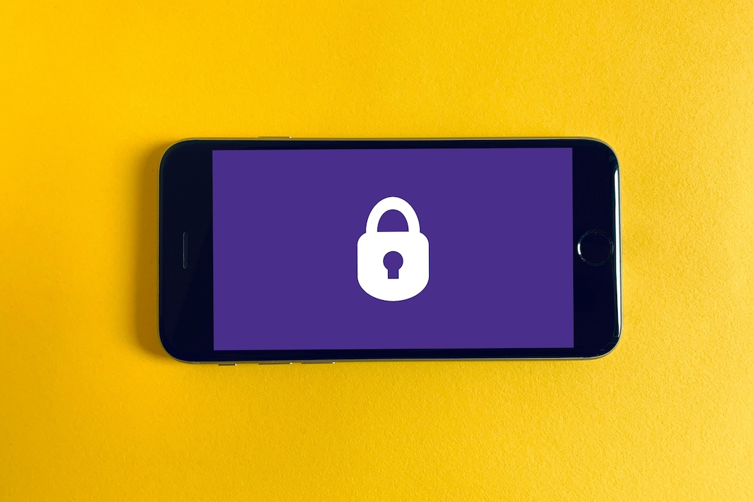 Black iphone on yellow background with a padlock. Photo by Franck on Unsplash